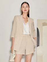 a woman in camel blazer and camel shorts